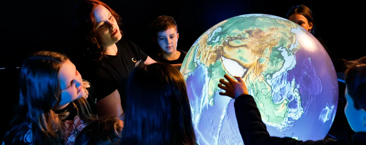A family discovering planetary content on an interactive sphere