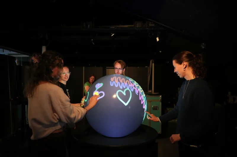 Visitors exploring WISDOME's interactive PufferTouch experience together
